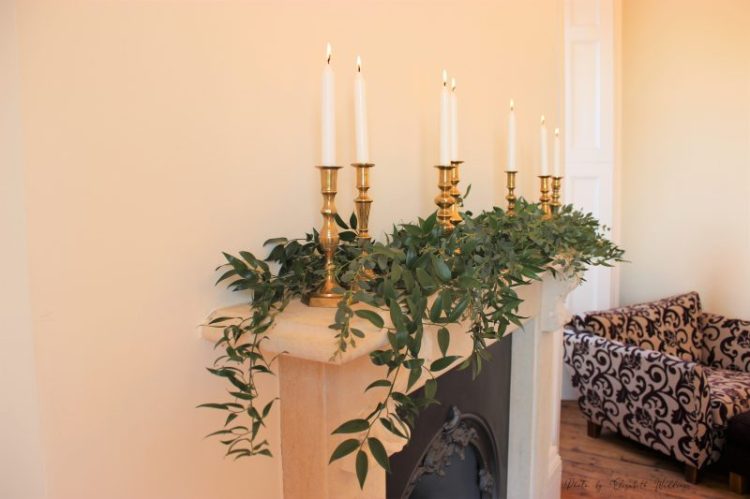 Brass candlesticks, white and foliage mantelpiece decor, styling by Elizabeth Weddings